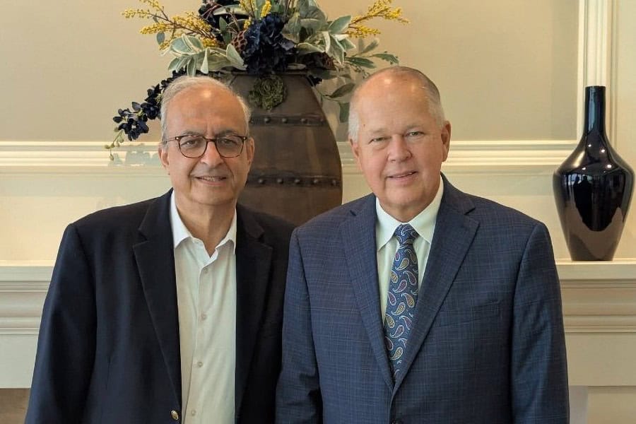 Rev. Botrus Mansour and Dr. Billy Wilson standing together indoors.