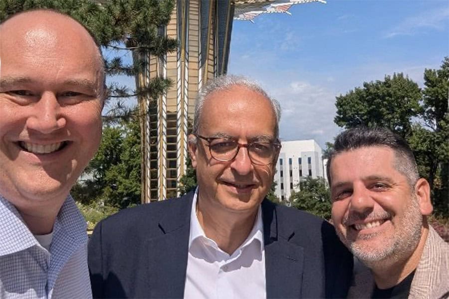 Rev. Botrus Mansour with two colleagues on the Oral Roberts University campus, with the ORU Prayer Tower behind them.