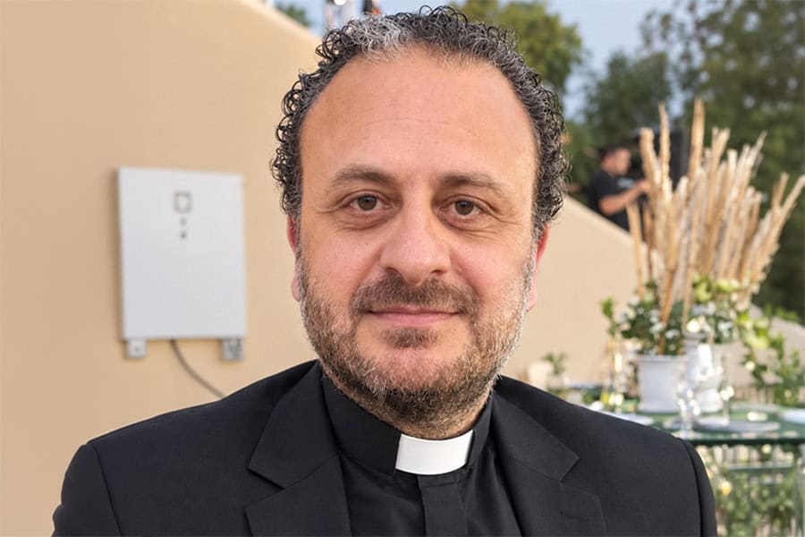 Catholic priest with clerical collar smiling outdoors